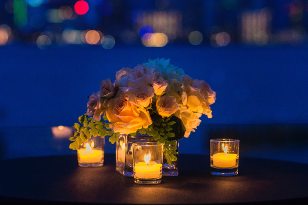 photo d'un bouquet de fleurs sur une table entouré de petites bougies